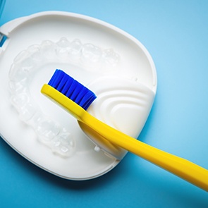 Transparent aligners in a case next to a toothbrush