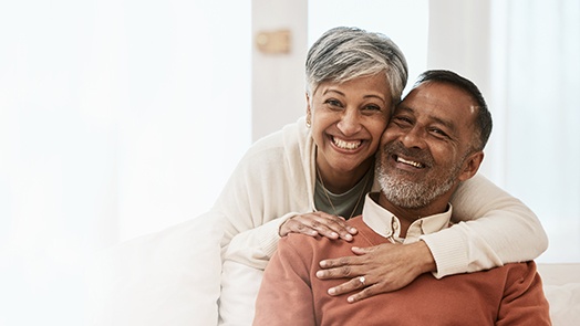 Senior man being hugged from behind by senior woman