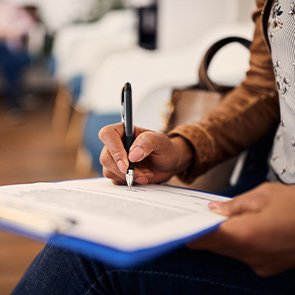 Woman filling out dental insurance form in lobby