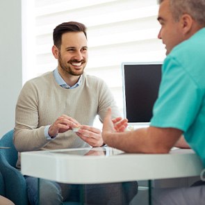 Dentist and couple talking in dental office