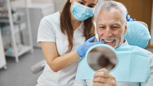 a patient checking his teeth after dental implant salvage