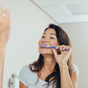 Closeup of woman brushing her teeth in bathroom