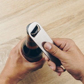 Closeup of patient using bottle cap opener