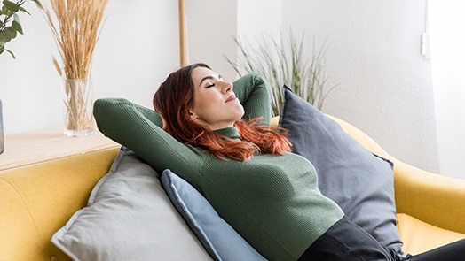 Woman relaxing comfortably on sofa at home